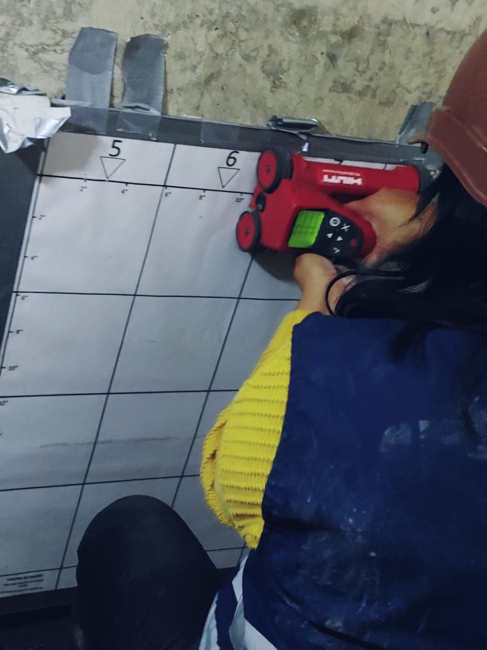 Técnico escaneando un muro de concreto con escáner Hilti sobre cuadrícula de referencia