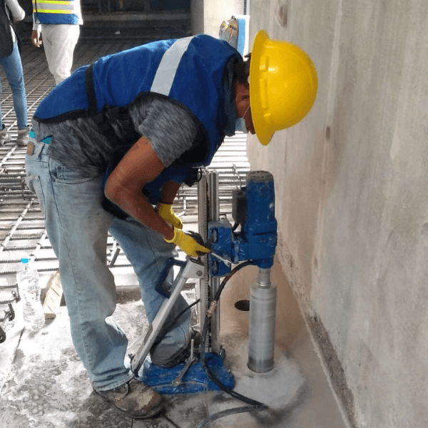 Técnico de Perforación con Diamante perforando una losa de concreto con perforadora de diamante